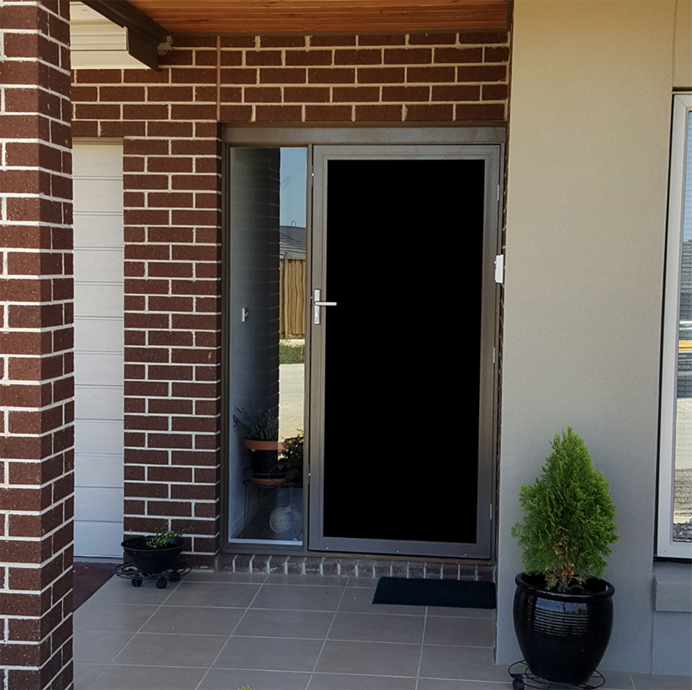 Mainstay Privacy Mesh installed in a screen door outside a house. The screen door blocks the view inside the house.